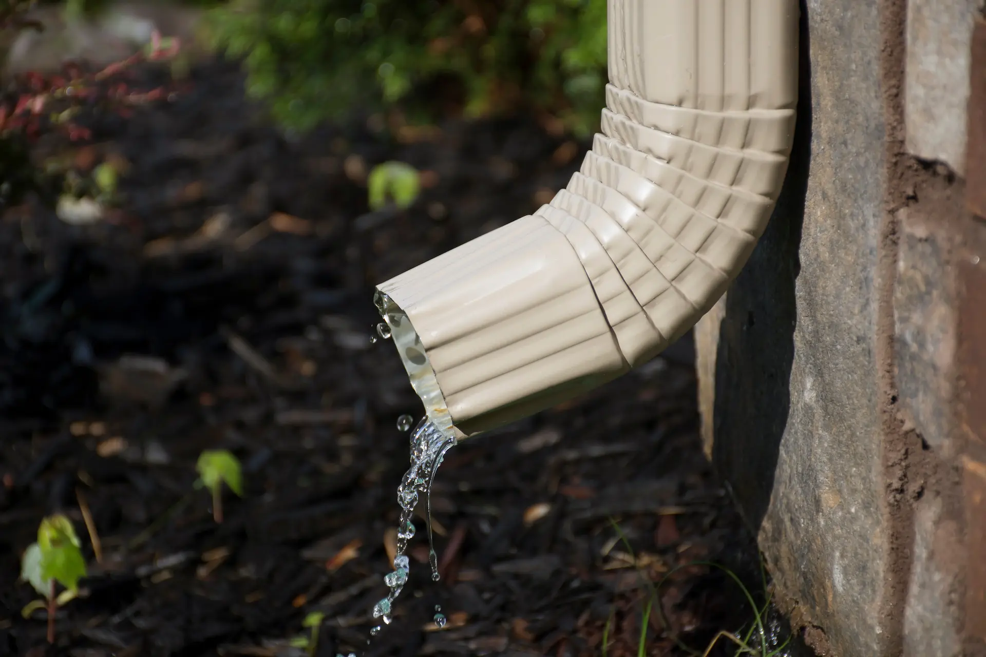 bottom of a gutter with water coming out