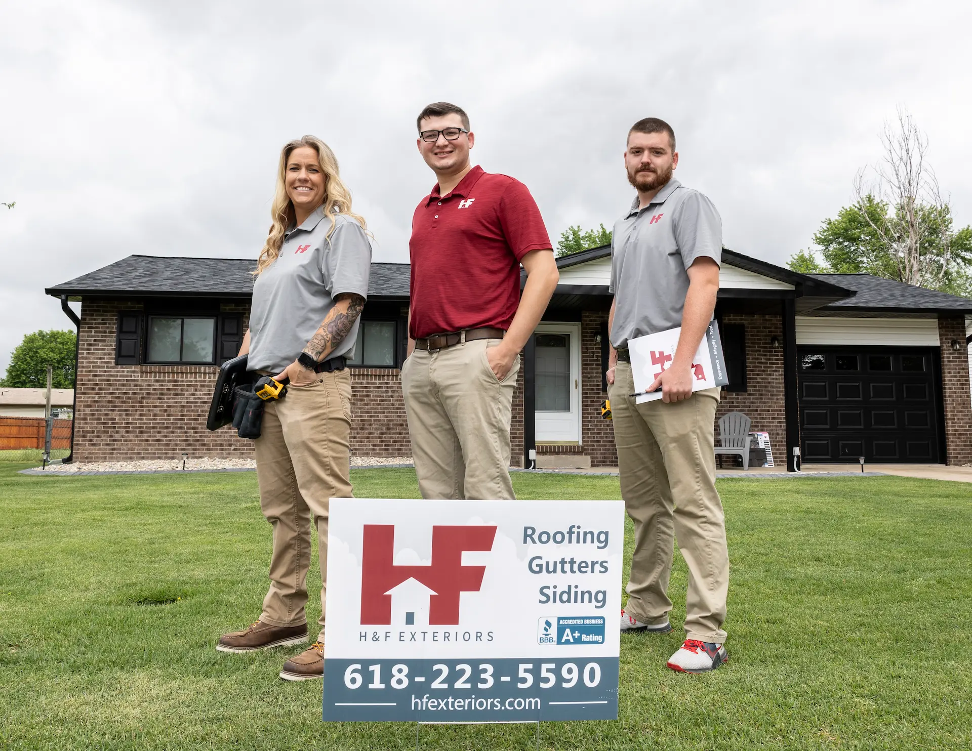 h&f employees standing next to a sign