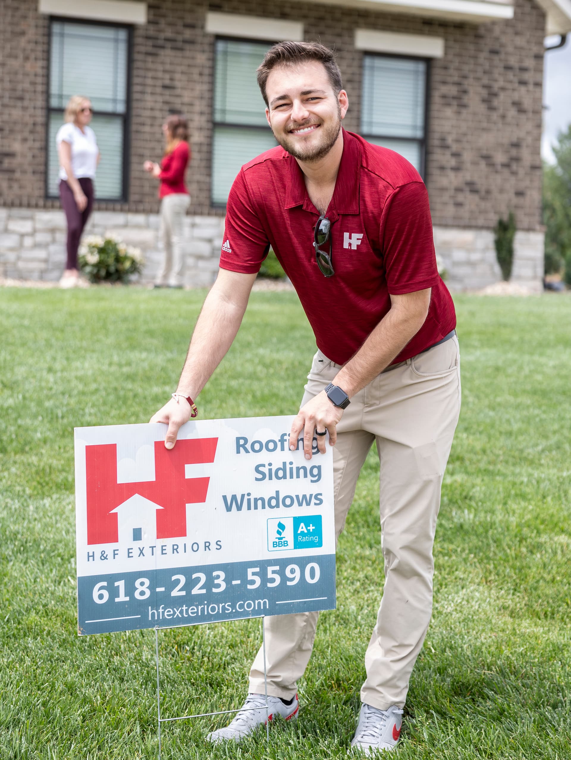 member of h&f team standing with a h&f sign