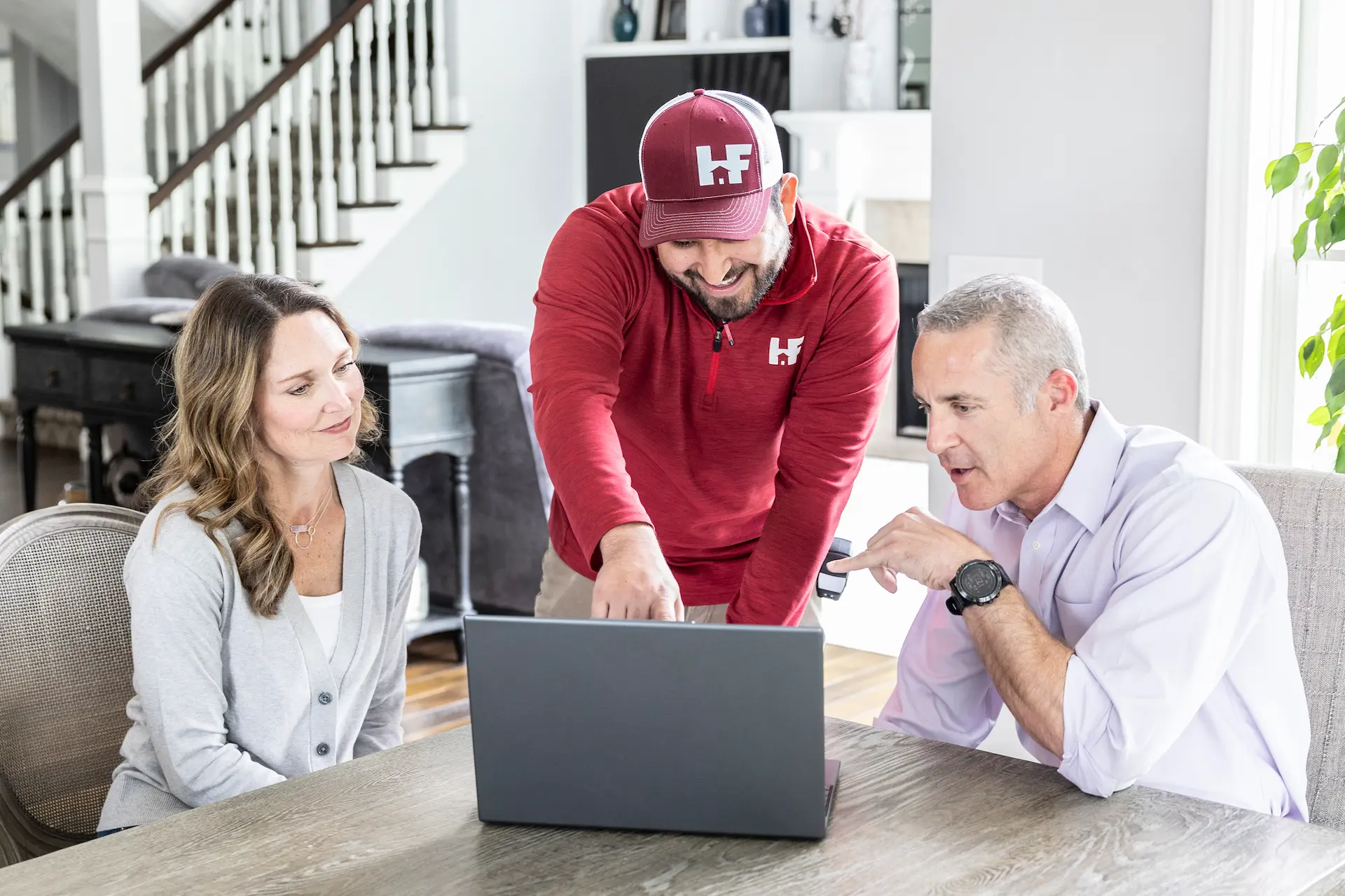 hfe employee showing clients a laptop